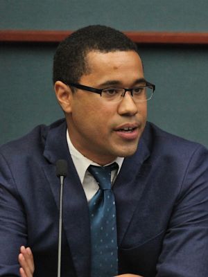 A man in a suit sitting at a table.